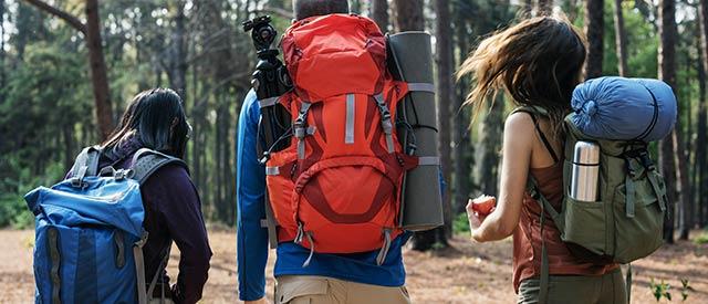 students hiking in the woods with lots of outdoor recreation euipment